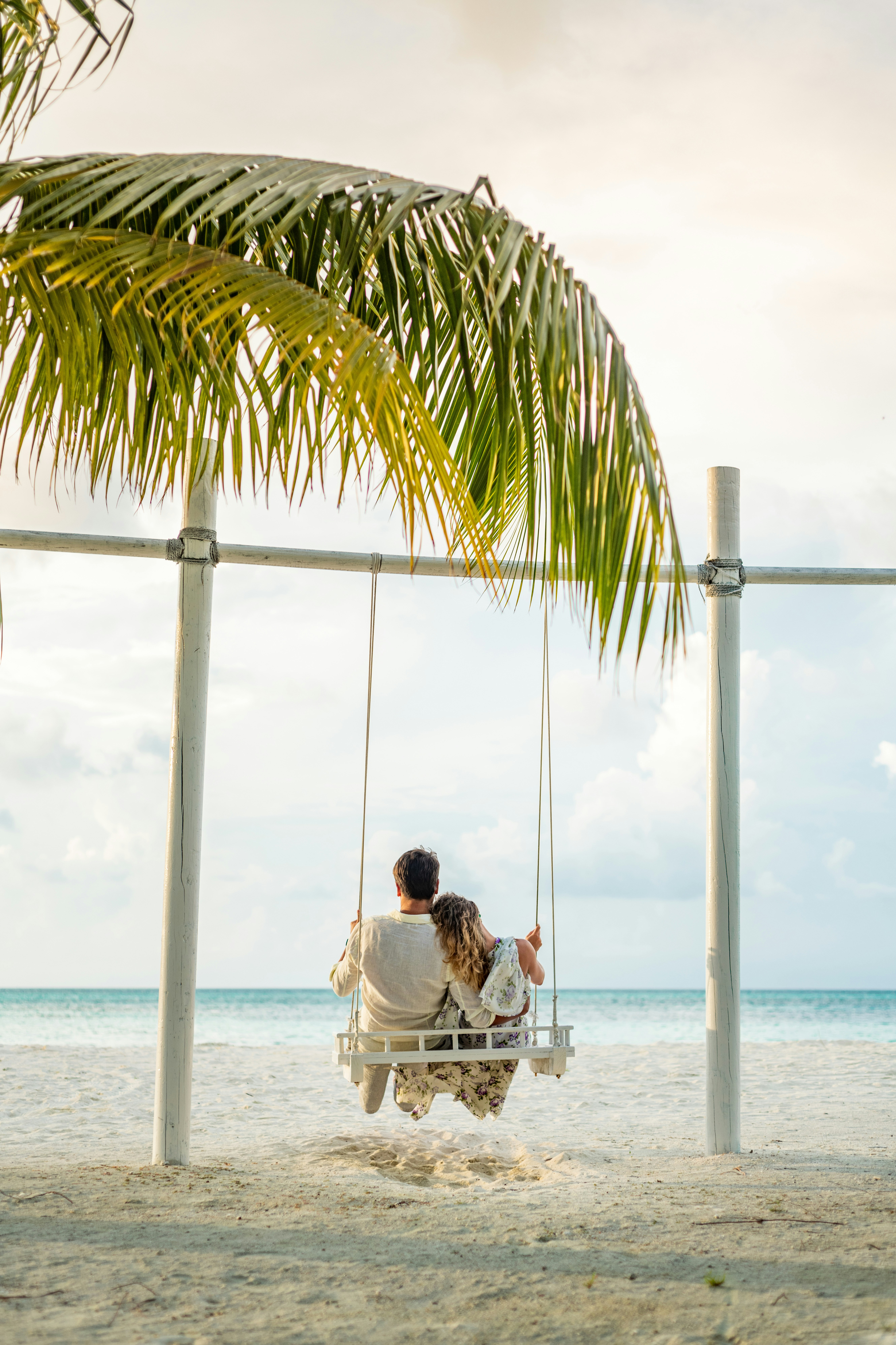 Couple profitant d’une balançoire au bord de la plage aux Maldives